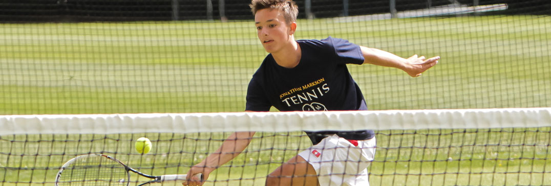 Giocatore di tennis a rete su campo in erba